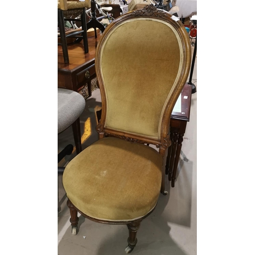 437 - A Victorian walnut low seat chair with carved back, upholstered in gold