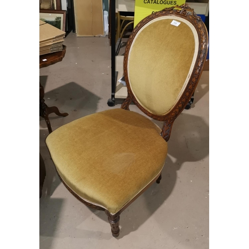 438 - A Victorian walnut low seat nursing chair with oval carved back, upholstered in gold