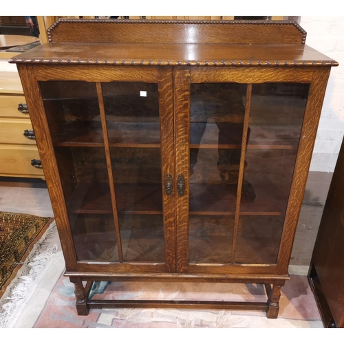 321 - A 1930's oak display cabinet enclosed by 2 glazed doors
