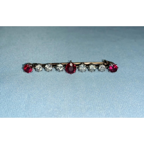 283 - An early 20th century yellow metal bar brooch set 6 diamonds, 1 carat gross approx., and 3 ruby colo... 