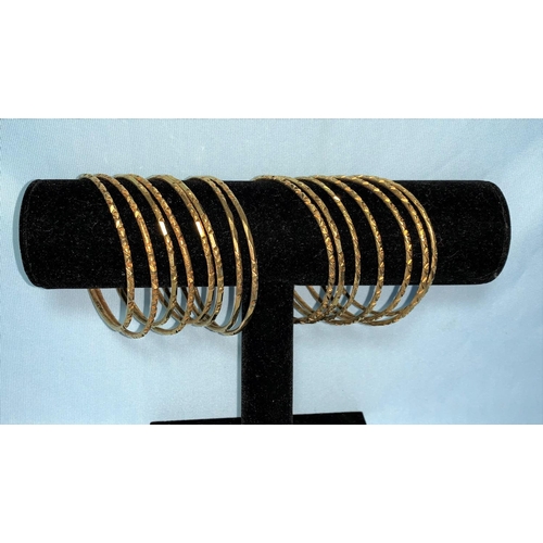 284 - Fifteen Egyptian yellow metal marriage bangles with relief decoration, bearing Egyptian hallmarks, t... 