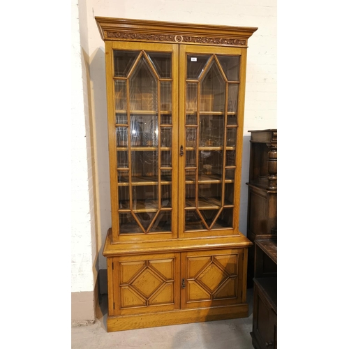 625 - An Edwardian golden oak full height bookcase with moulded cornice and carved frieze, 2 astragal glaz... 