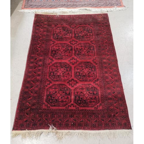 645 - An Afghan rug with repeat octagonal pattern on red ground, 200 x 136 cm