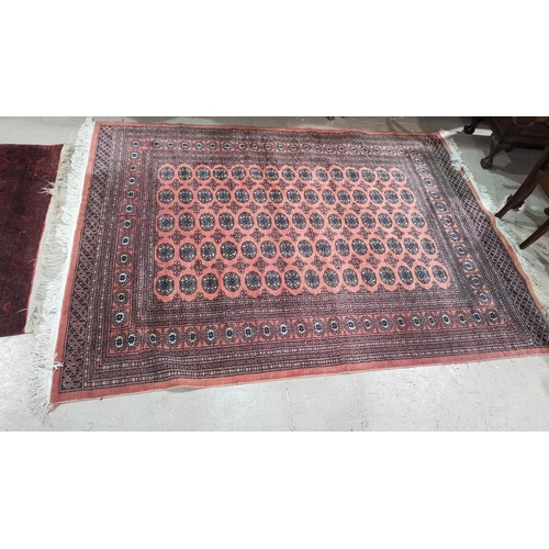 647 - A Pakistan Bokhara rug with elephant foot motif repeated on a dusky pink ground, 250 x 195 cm