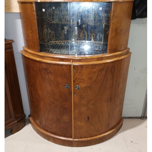 665 - A 1950's bow front cocktail cabinet with patterned mirror interior