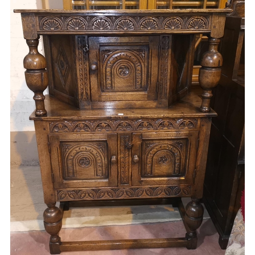 684 - A golden oak dwarf court cupboard/buffet with single cupboard over double cupboard enclosed by carve... 