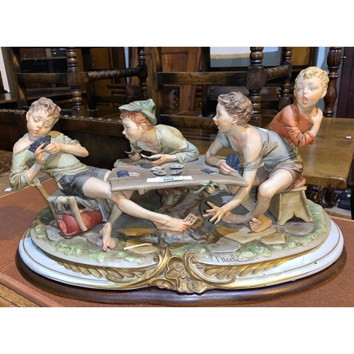 209 - A Capodimonte large colour bisque figure group of boy card players, signed 'Merli', width 55 cm