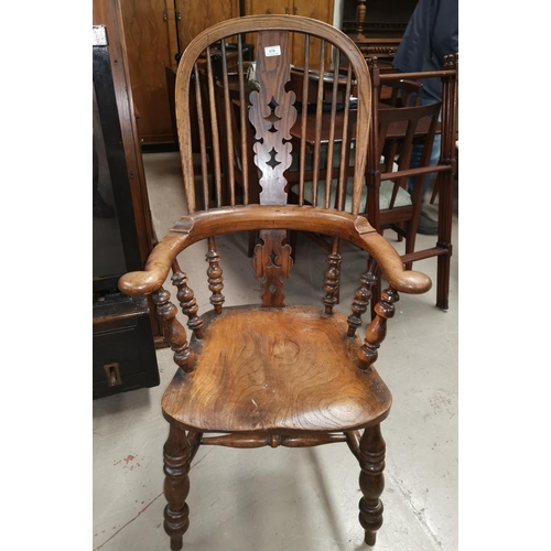576 - A 19th century elm Windsor armchair with pierced splat, out turned arms and solid seat, on turned le... 