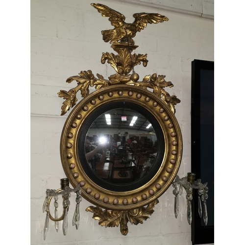 648 - A 19th century convex wall mirror in gilt ball frame with eagle finial and twin scroll sconces with ... 