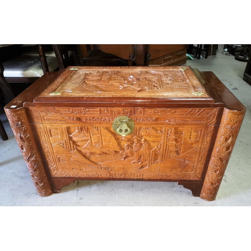 698 - A large oriental camphorwood chest depicting traditional scenes, length 104 cm