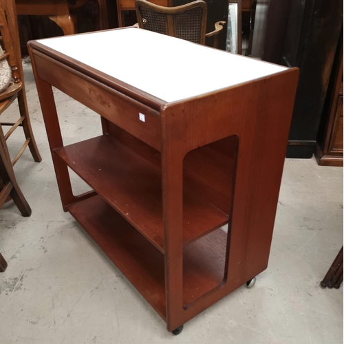 707 - A mid century teak tea trolley by McIntosh, with formica sliding top, multiple shelves and sliding d... 