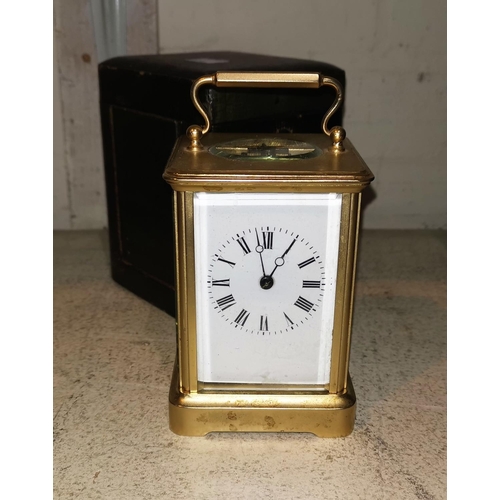 562 - A carriage clock in ogee brass case, with white enamel dial and striking movement, height 12 cm, in ... 