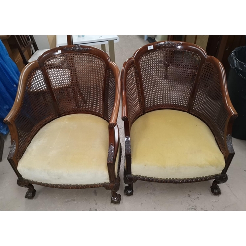 641 - An early 20th century near matching pair of tub shaped armchairs in mahogany with bergère caning, ov... 