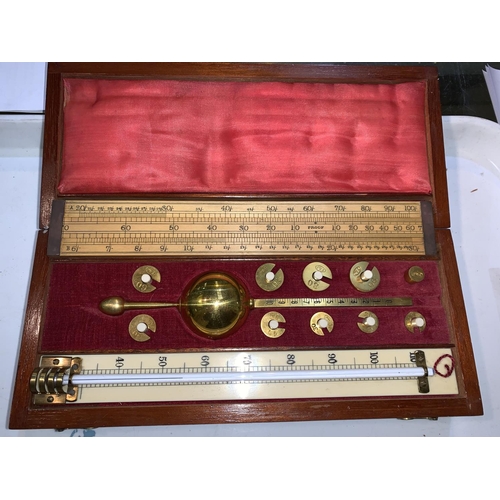 534 - A Sykes Hydrometer by Farrow and Jackson, London, with 23 cm thermometer, boxwood slide rule, mahoga... 