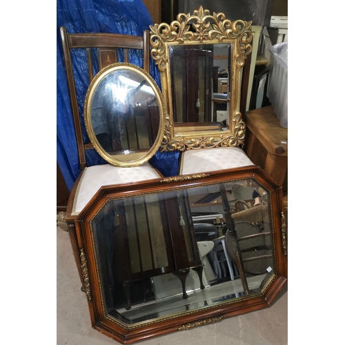 584 - A wall mirror in ornate gilt frame; a similar oval mirror; a mirror in canted rectangular frame