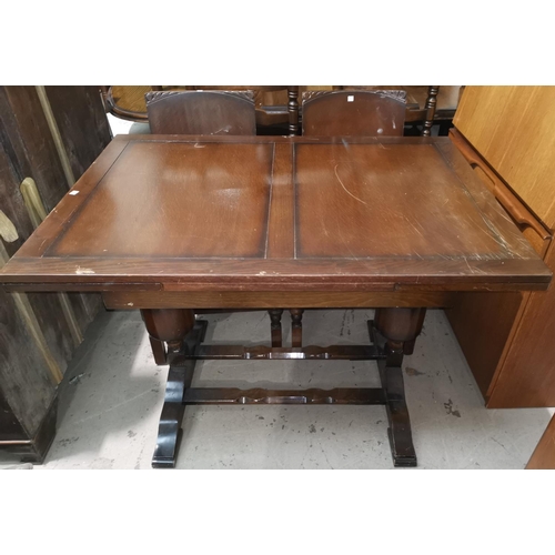 621A - A 1950's oak period style dining suite comprising draw leaf table, 4 panel back chairs, and a sidebo... 