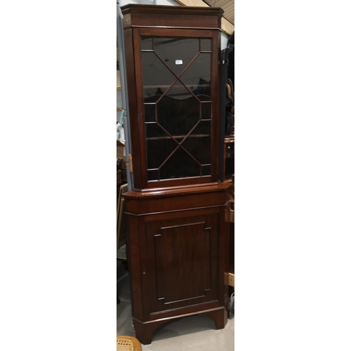 643 - A 19th century mahogany corner cupboard with glazed upper section and panelled base