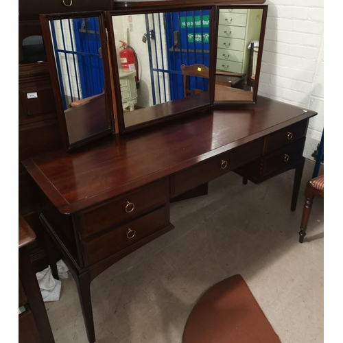 670 - A Stag mahogany dressing table with stool; 32 Stag bedside cabinets