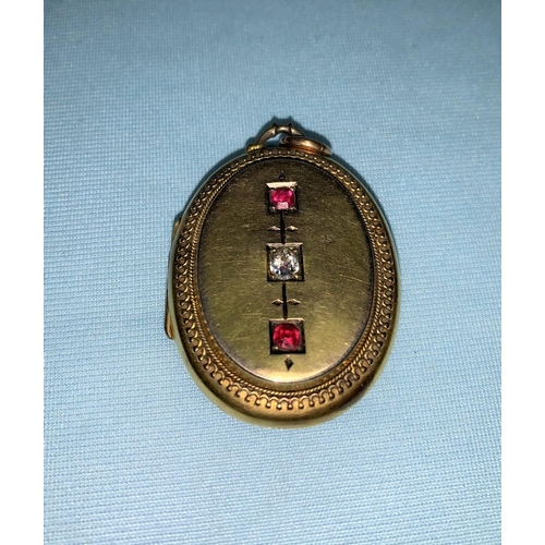 326 - An Edwardian yellow metal oval locket pendant set old cut diamond, 0.25 ct approx. and 2 ruby colour... 