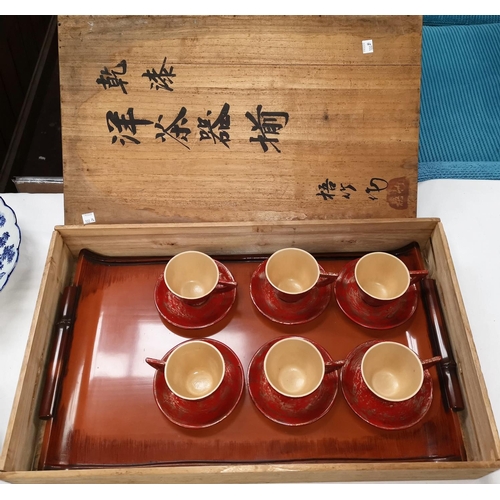 100b - An oriental set of 6 red lacquer cups and saucers, with inscribed rectangular box, 56 x 34 cm