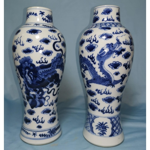 116 - A pair of Chinese blue and white baluster vases decorated with dragons, height 26cm