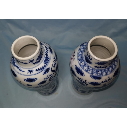 116 - A pair of Chinese blue and white baluster vases decorated with dragons, height 26cm