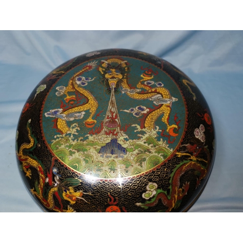 128 - A Chinese large circular cloisonné covered bowl decorated with dragons, etc., against a black and tu... 