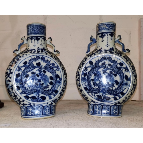 162 - A pair of Chinese porcelain moon flasks decorated with dragons in underglaze blue, 20 cm (one neck a... 