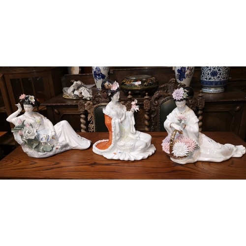 164 - Three oriental porcelain figures of reclining females, decorated with flowers
