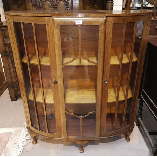 574 - A 1930's golden oak display cabinet with carved decoration and 2 glazed doors