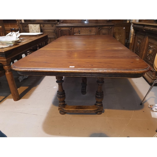 637 - An early 20th century French Provincial extending oak dining table with 3 spare leaves, on turned le... 