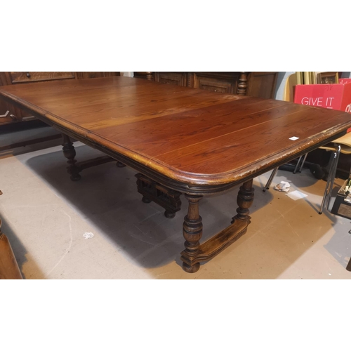 637 - An early 20th century French Provincial extending oak dining table with 3 spare leaves, on turned le... 