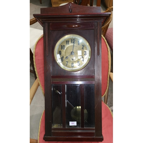 491 - A mahogany cased wall clock with brass dial and bevelled glass