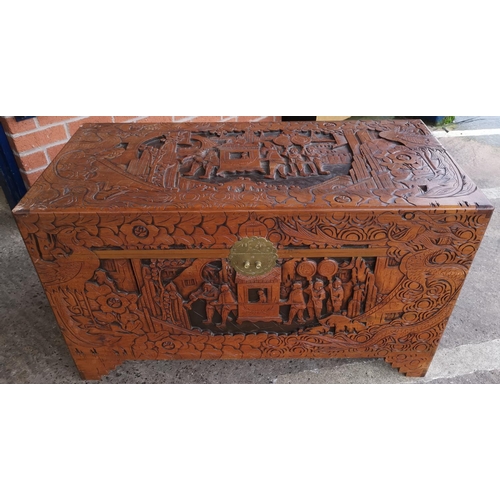 545a - A large oriental carved camphor wood chest with extensive carving