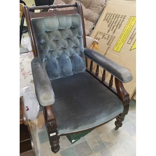 549 - An early 20th century mahogany armchair with spindle rails, deeply buttoned blue velvet upholstery