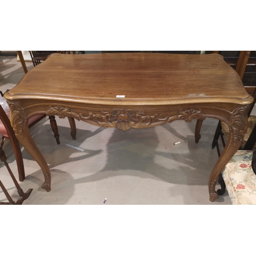 571 - A late 19th century French provincial centre/library table in carved walnut, on tapering cabriole le... 