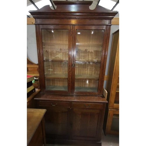 581 - An Edwardian oak full height bookcase with 2 glazed doors over 2 drawers and double cupboard