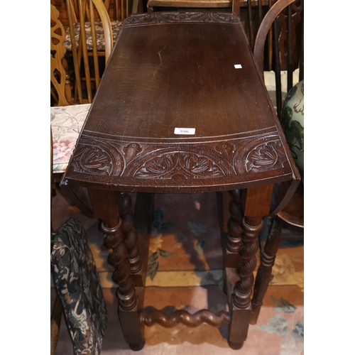 596 - A 1930's carved oak drop leaf table with circular top, on barley twist legs