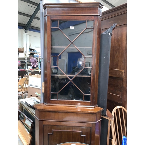 561A - A 19th century mahogany corner cupboard with glazed upper section and panelled base