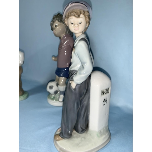 85 - 2 Lladro boy figures - footballer & boy with sack; Nao boy footballer