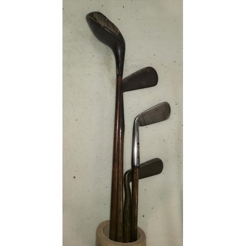 794 - An early 20th century golf bag containing a hard forged mashie St Andrews & 3 other clubs