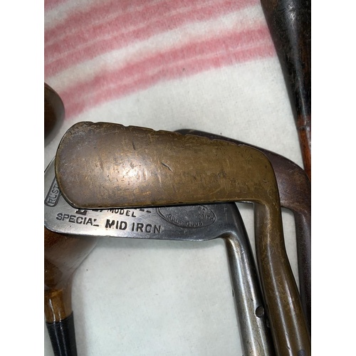 794 - An early 20th century golf bag containing a hard forged mashie St Andrews & 3 other clubs