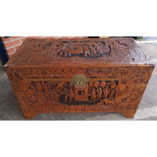 567 - A large oriental carved camphor wood chest with extensive carving