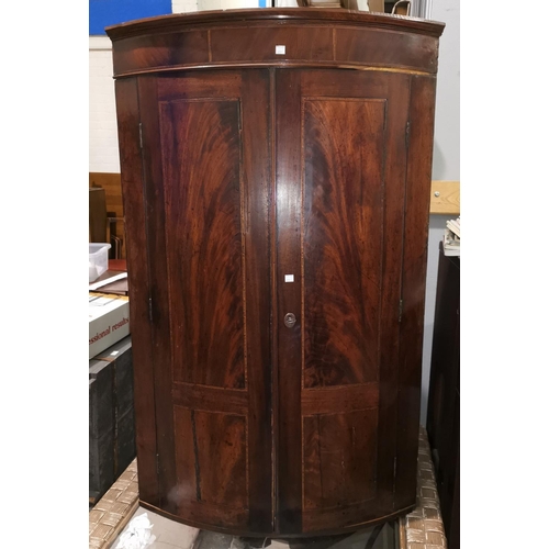 659 - A Georgian bow front inlaid mahogany corner cupboard