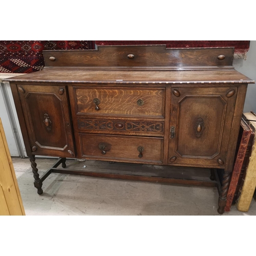 641 - A 1930's Jacobean style sideboard of 2 cupboards and 3 central drawers