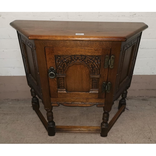 553 - A canted oak reproduction hall cabinet; a drop leaf occasional table with oval swivel top