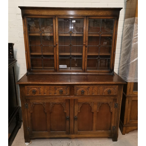 561 - A Jacobean style carved oak dresser with 3 leaded glass doors, 2 drawers and double cupboard