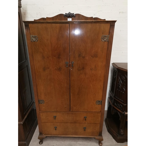 565 - A reproduction walnut tallboy with double cupboard over 2 drawers