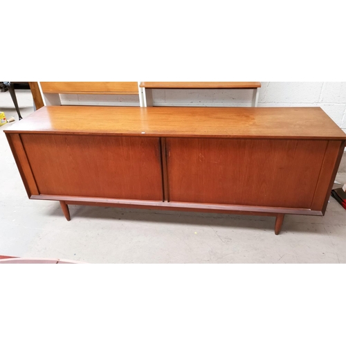 575A - A 1960s teak long low line sideboard with tambour doors with four central drawers two with cutlery c... 