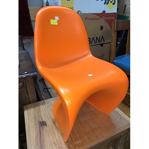 657 - A mid century style moulded child's chair in orange